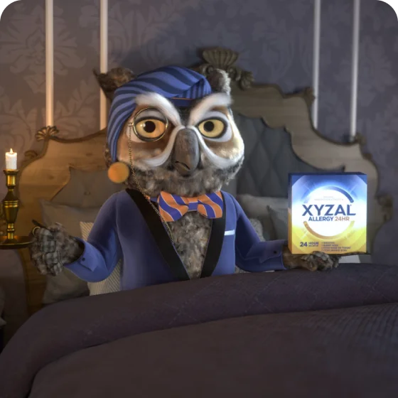 Xyzal's mascot, Nigel the owl, wearing a suit and a stylish bow tie, complete with a night cap, sitting on his bed with a Xyzal Allergy 24HR next to him.